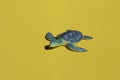 Summer bright concept - blue toy turtle on a yellow background Royalty Free Stock Photo