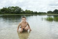 Summer bright sunny day boy sitting in the water.