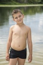 Summer bright sunny day boy stands in water.