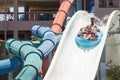 In the summer, on a bright sunny day, in a water park, father and daughter slide down the hill Royalty Free Stock Photo