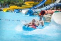 In the summer, on a bright sunny day, in a water park, father and daughter slide down the hill Royalty Free Stock Photo