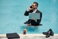 Summer business. Funny businessman in suit with laptop and phone in pool water. Remote summer business. Businessman