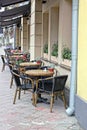 summer cafe from a row of brown round wooden tables with black wicker chairs Royalty Free Stock Photo