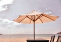 Summer cafe by sea, wooden table , clean sand and textile umbrella. deserted beach. retro noise effect