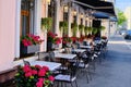 Summer cafe on the street of the big city. An open-air restaurant in an old house. Cafe decorated with flowers and sitting at a Royalty Free Stock Photo