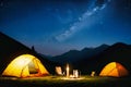 Summer camping in the mountains. Tents in the night with the starry sky and clouds in the background. Royalty Free Stock Photo