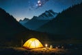 Summer camping in the mountains. Tents in the night with the starry sky and clouds in the background. Royalty Free Stock Photo