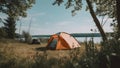 summer camping site with one orange tent near summer lake, neural network generated picture Royalty Free Stock Photo