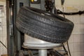 Summer car tire half taken from the disk to perform tire mounting and fitting on a special machine in the workshop for repairing Royalty Free Stock Photo