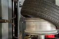 Summer car tire half taken from the disk to perform tire mounting and fitting on a special machine in the workshop for repairing Royalty Free Stock Photo