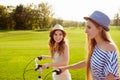 At summer cherful happy girls with hat riding bicycles on the park Royalty Free Stock Photo