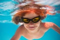 Summer child boy relax at aquapark. Summertime vacation. Little kid swim underwater in pool. Kid wearing summer goggles