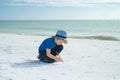 Summer child face. Cute kid kid drawing a on sand enjoying summer sea and dreaming. Funny little boy play on summer Royalty Free Stock Photo