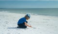 Summer child face. Cute kid kid drawing a on sand enjoying summer sea and dreaming. Funny little boy play on summer Royalty Free Stock Photo