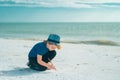 Summer child face. Cute kid kid drawing a on sand enjoying summer sea and dreaming. Dreamy kids face. Daydreamer child Royalty Free Stock Photo