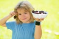 Summer child face. Child eat cherries in the summer. Kid is picking cherries in the garden. Royalty Free Stock Photo