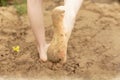 In summer, the child plays on the beach, runs barefoot on the sand. Sea tour. Children`s feet in the sand. Royalty Free Stock Photo