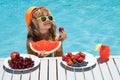 Summer child by the pool eating fruit. Portrait of summer kids. Summer kids. Little kid boy relaxing in a pool having Royalty Free Stock Photo