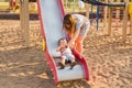 Summer, childhood, leisure and family concept - happy child and his mother on children playground climbing frame Royalty Free Stock Photo