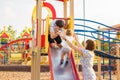 Summer, childhood, leisure and family concept - happy child and his parents on children playground climbing frame Royalty Free Stock Photo