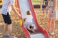 Summer, childhood, leisure and family concept - happy child and his parents on children playground climbing frame Royalty Free Stock Photo