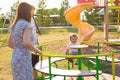 Summer, childhood, leisure and family concept - happy child and his parents on children playground climbing frame Royalty Free Stock Photo