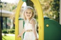 Summer, childhood, leisure, gesture and people concept - happy little girl playing on children playground