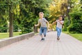 Summer, childhood, leisure and people concept - happy little boy and girl playing tag game and running outdoors on green