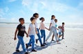 Summer, children and friends walking on the beach, holding hands together for holiday or vacation. Nature, diversity and Royalty Free Stock Photo