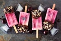 Summer chocolate and nut dipped cherry popsicles over a dark slate background Royalty Free Stock Photo