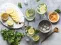 Summer citrus lemonade with ice in two bulging glasses, sugar in little white plate, slices of citrus on a ceramic white board and Royalty Free Stock Photo