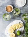 Summer citrus lemonade with ice in two bulging glasses, sugar in little white plate, slices of citrus on a ceramic white board and Royalty Free Stock Photo