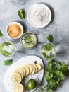 Summer citrus lemonade with ice in two bulging glasses, sugar in little white plate, slices of citrus on a ceramic white board and Royalty Free Stock Photo