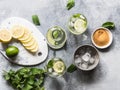 Summer citrus lemonade with ice in two bulging glasses, sugar in little white plate, slices of citrus on a ceramic white board and Royalty Free Stock Photo