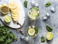 Summer citrus lemonade with ice in two bulging glasses, sugar in little white plate, slices of citrus on a ceramic white board and Royalty Free Stock Photo