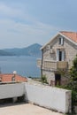 Summer city landscape - apartment buildings with a red tiled roof against the blue sky and the Adriatic Sea, Montenegro.