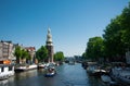 Summer cityscape of Amsterdam. Modern architecture. Touristic boats in canal. Tourism in Europe