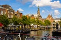 Summer cityscape of Leiden with townhouses along canal and belfry of town hall