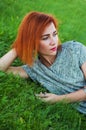 Summer close up portrait of pretty smiling young woman, laying on the grass, enjoy her vacation, natural make up red Royalty Free Stock Photo