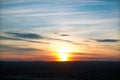 Summer cloudy sunset in the field, traces of the plane in the sky Royalty Free Stock Photo