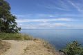 Summer coastal landscape - clear Black Sea under blue sky. Sandy high bank with trees. Copy space Royalty Free Stock Photo