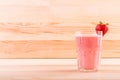 Summer cocktail from bright red strawberries and organic milk on a light brown wooden table. Strawberry smoothie in a glass. Royalty Free Stock Photo