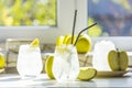 Summer cocktail with green apple and ice on the white table near window in the sunny summertime. Selective focus image with copy Royalty Free Stock Photo