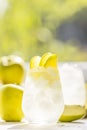 Summer cocktail with green apple and ice on the white table near window in the sunny summertime. Selective focus image with copy Royalty Free Stock Photo