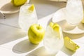 Summer cocktail with green apple and ice on the white table near window in the sunny summertime. Selective focus image with copy Royalty Free Stock Photo