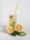 Summer cocktail lemonade in a glass cup with ice and straw, lemon, fresh cucumber and mint leaves. homemade lemonade to quench Royalty Free Stock Photo