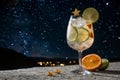 Summer cocktail with lime and oranges under starry sky Royalty Free Stock Photo