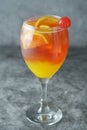 Summer cocktail. Orange juice with mint, syrop, fruit slices and cherry with ice. Dark background Royalty Free Stock Photo