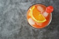 Summer cocktail. Orange juice with mint, syrop, fruit slices and cherry with ice. Dark background Royalty Free Stock Photo