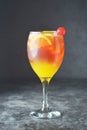 Summer cocktail. Orange juice with mint, syrop, fruit slices and cherry with ice. Dark background Royalty Free Stock Photo